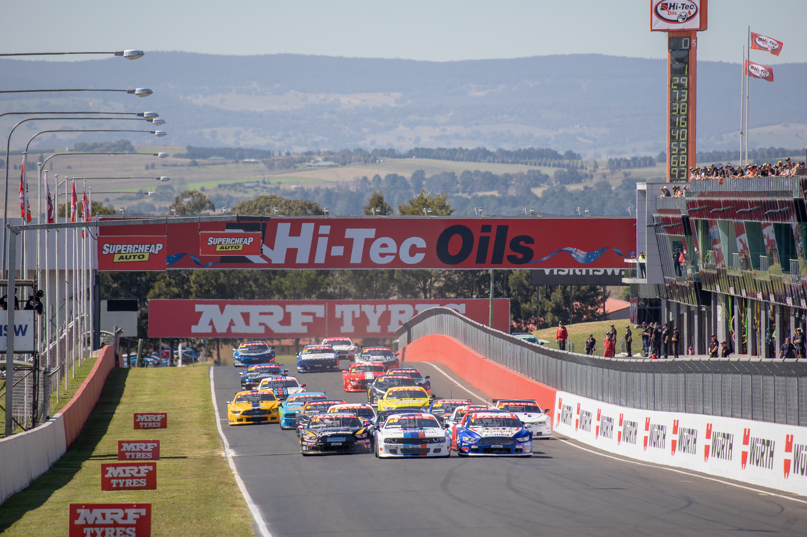 V8 touring cars racing at speed on an Australian motorsport circuit